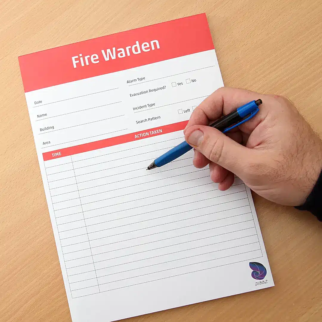 A person using a pen to tick off completed evacuation steps on the Fire Warden checklist.